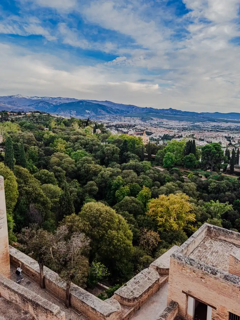 View over a Spanish city from a tree-lined hillside overlook.