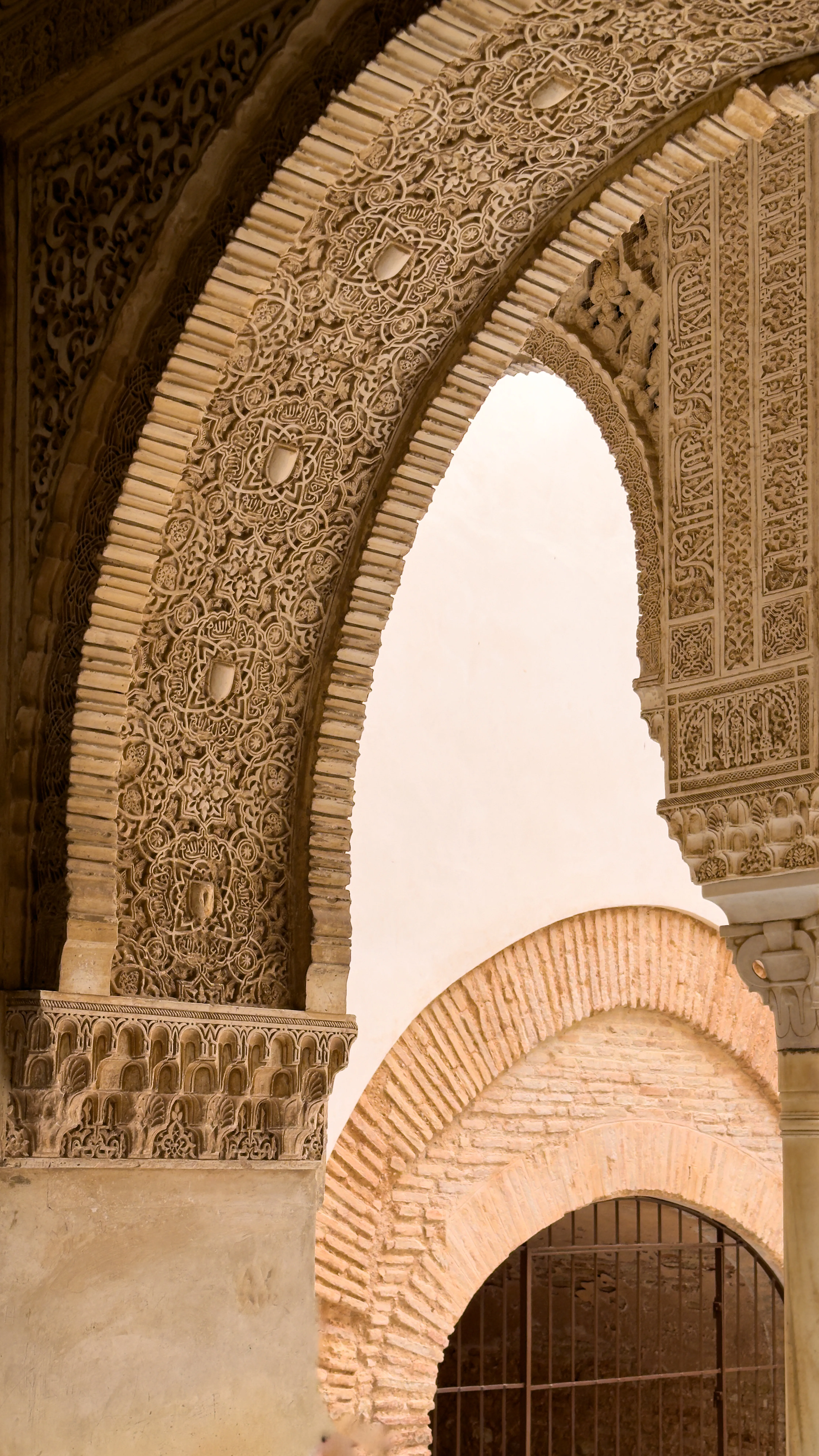 Detailed carved stone arch with warm light passing through.