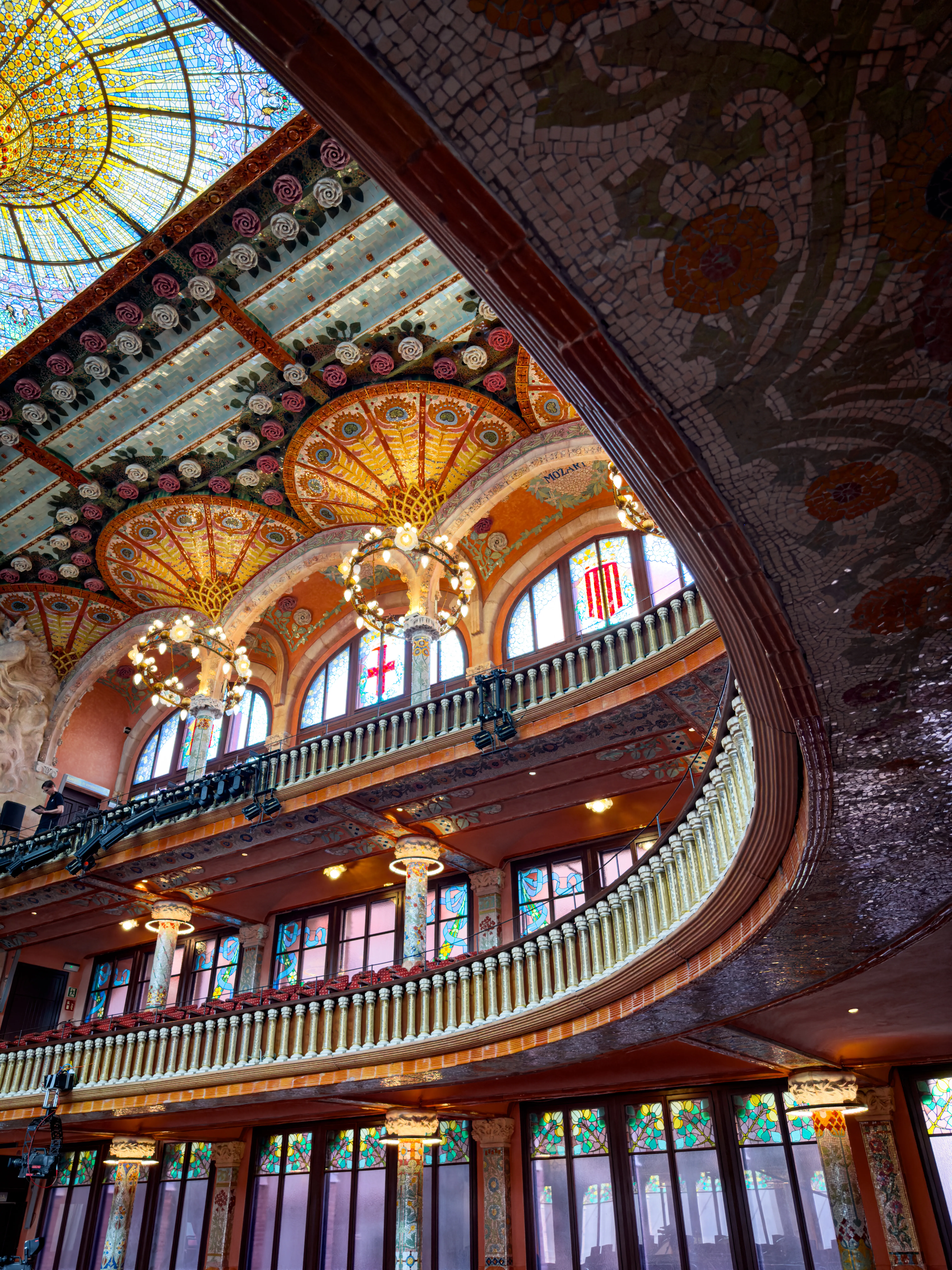 Ornate concert hall interior with stained glass and painted architectural details.