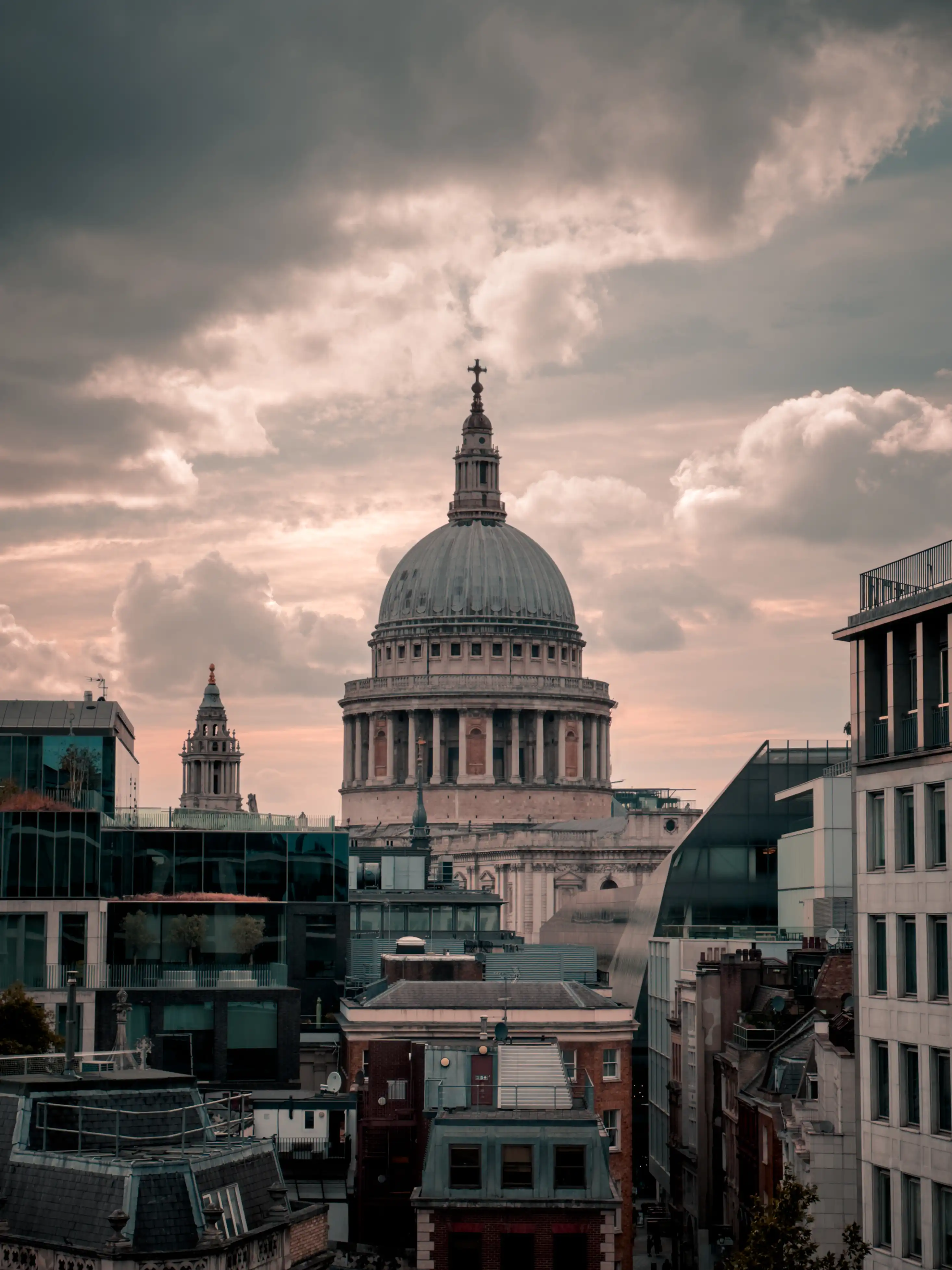 St. Paul's Cathedral and London skyline under a cloudy sky.