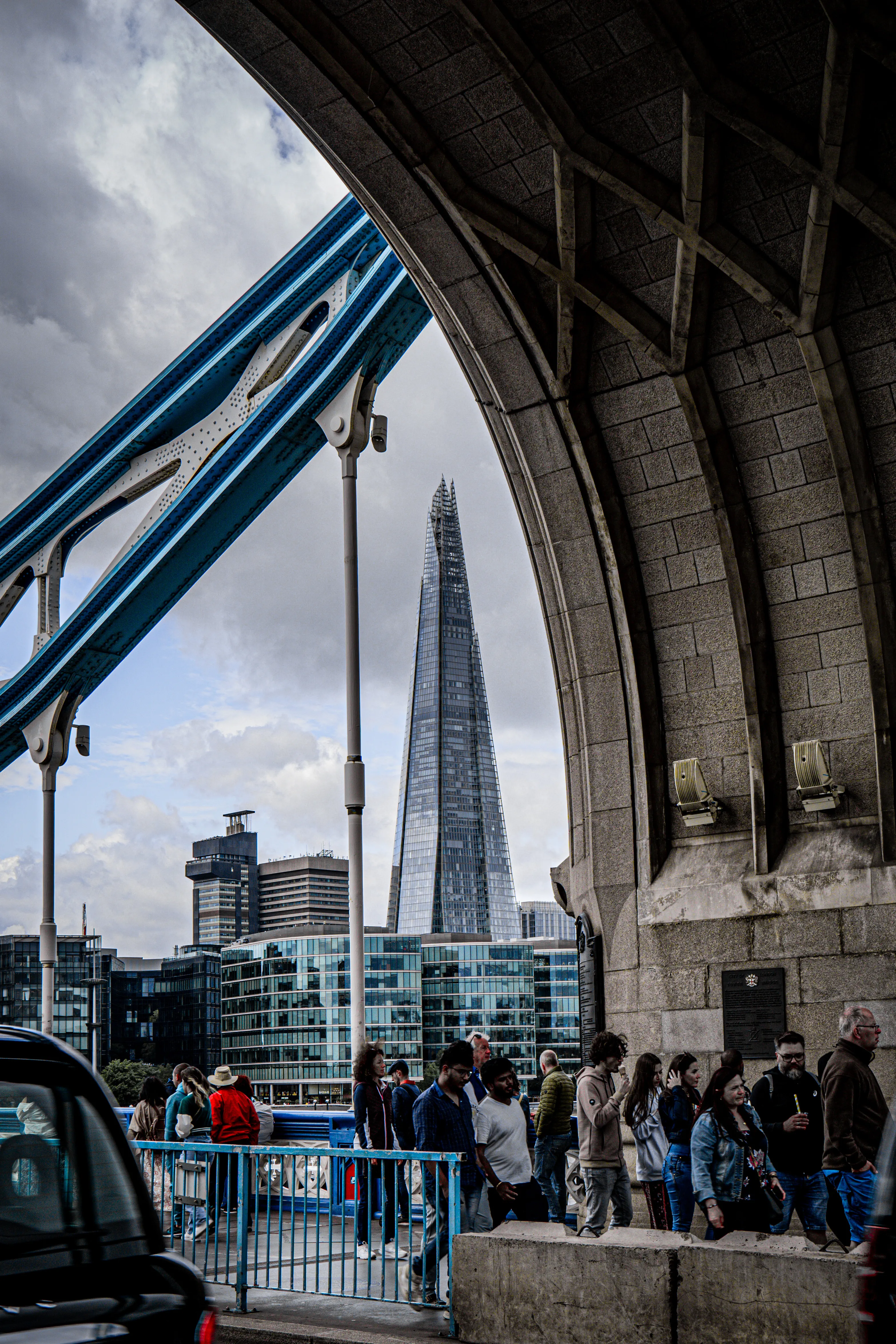 The Shard seen through bridge structure above a busy London street.