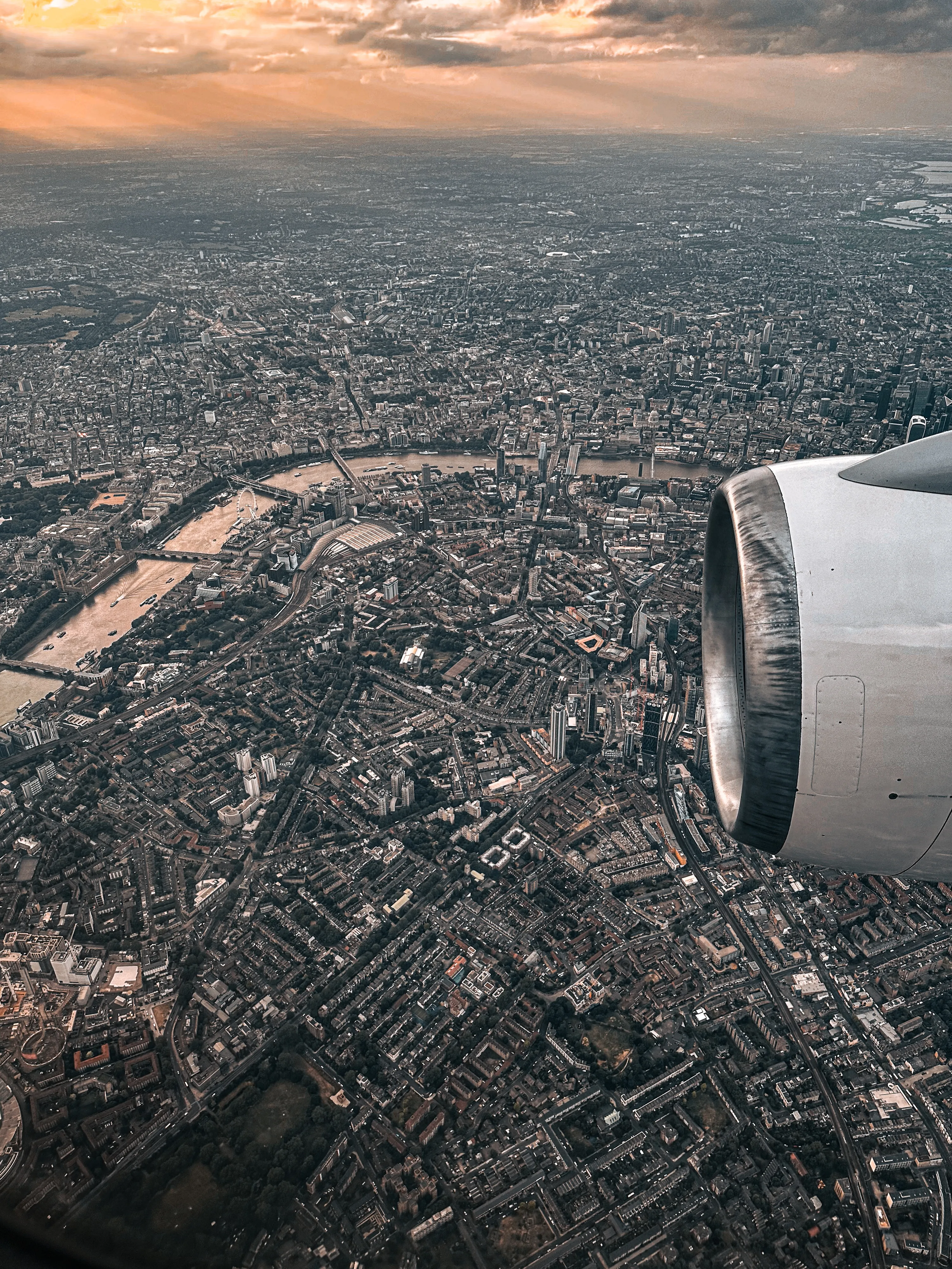 Aerial view of London and the Thames beside an airplane engine.