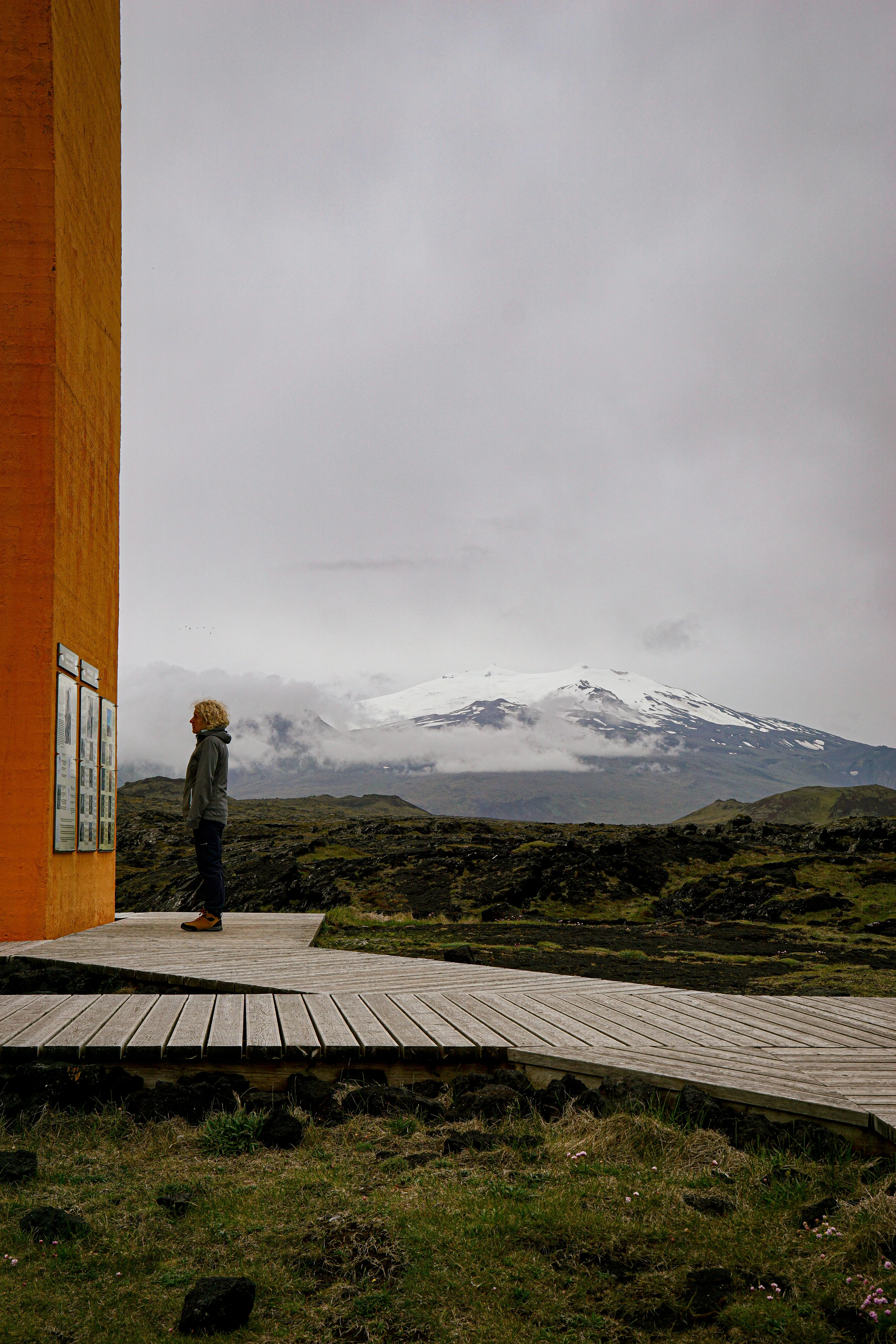 Snowy Icelandic landscape seen from beside a warm orange window frame.