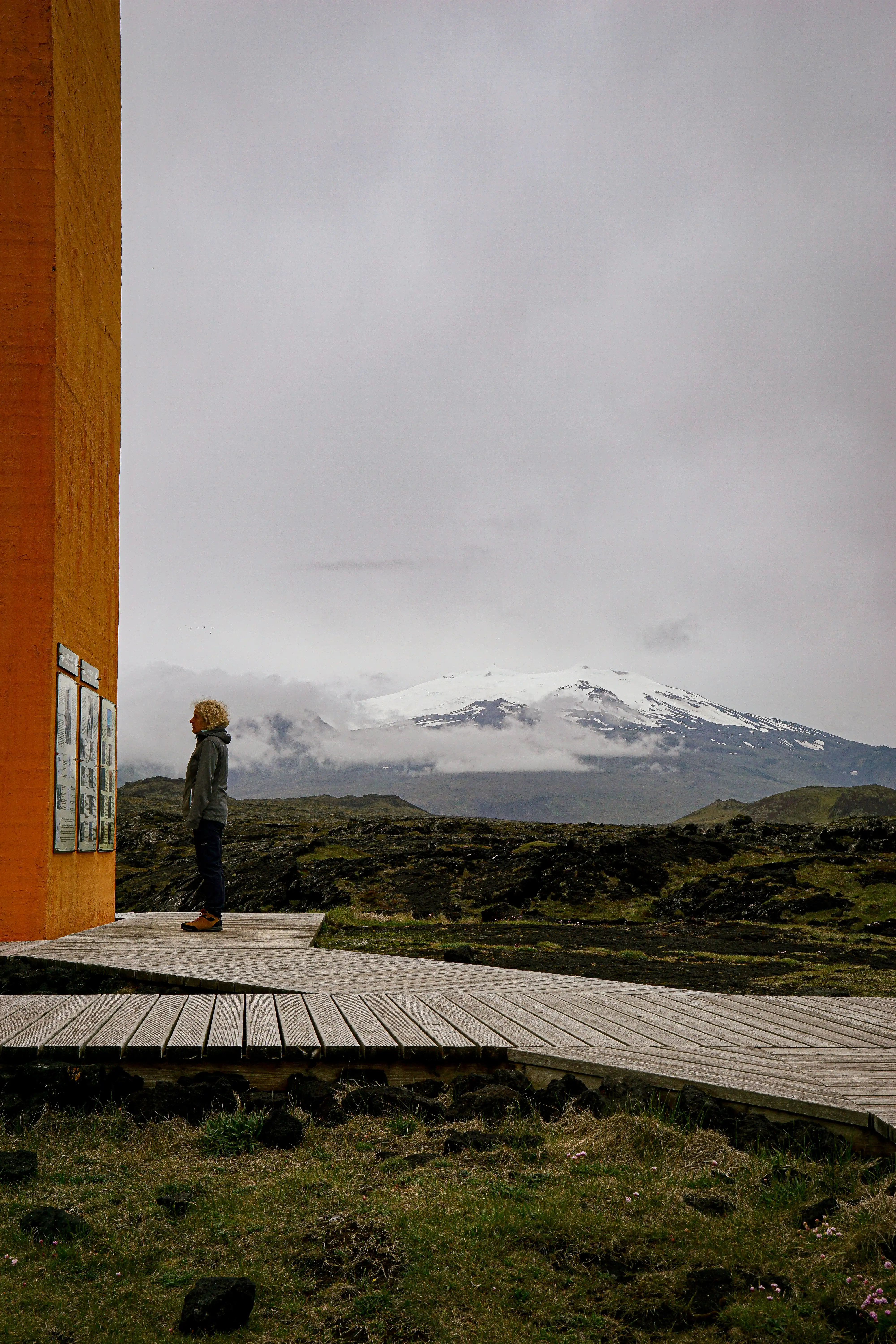 Snowy Icelandic landscape seen from beside a warm orange window frame.